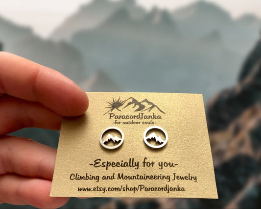 Pair of mountain-themed earrings on a ParacordJanka card with a mountainous background.